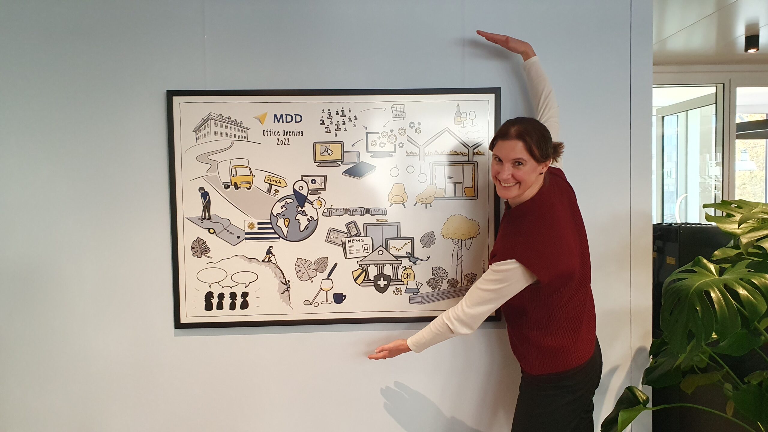 Business visual created by speakture printed in large format and framed hanging on the wall with Dana Rulf standing next to it